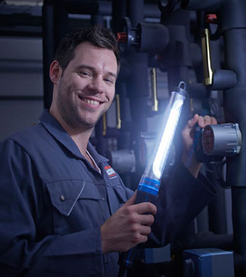 Uma luz de trabalho LED melhora a vis&atilde;o de um homem que repara um autom&oacute;vel