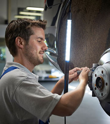 Uma luz de trabalho LED melhora a vis&atilde;o de um homem que repara um autom&oacute;vel